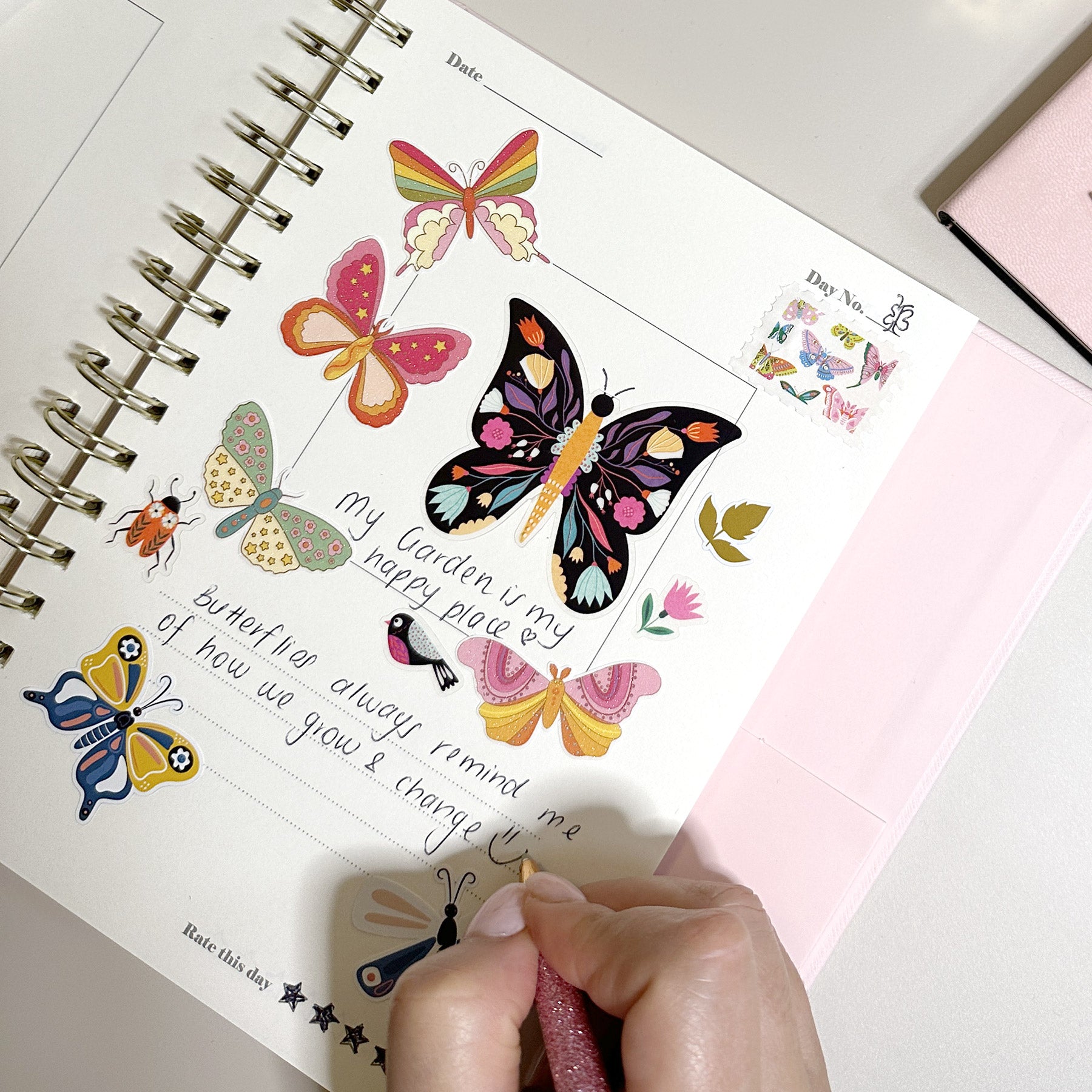 A woman writes in her journal featuring Postix stickers