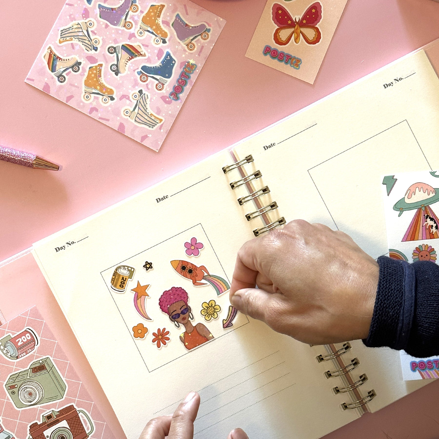 A woman decorates her journal with Postix stickers